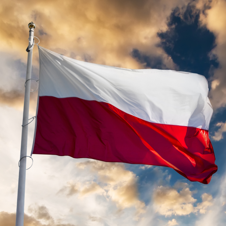Biało-czerwona flaga powiewająca na tle nieba z chmurami