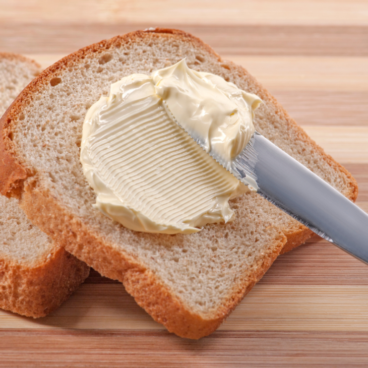 Kromka chleba posmarowana masłem.